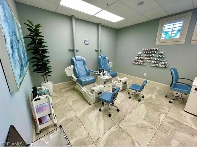 Unfurnished office with a drop ceiling and baseboards