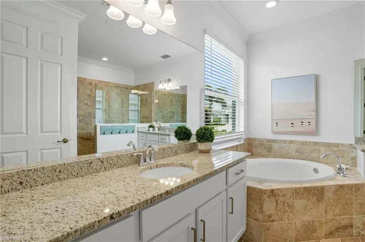 Bathroom featuring ornamental molding, vanity, walk in shower, a bath, and recessed lighting