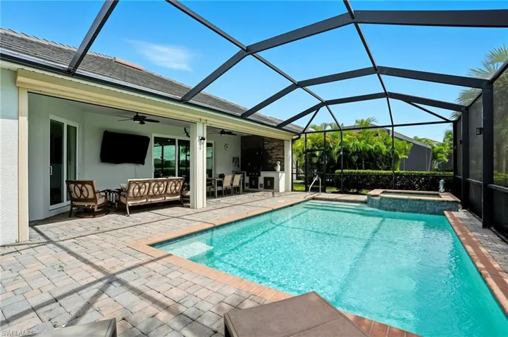 View of swimming pool featuring a sunroom, a ceiling fan, glass enclosure, a patio, and a pool with connected hot tub