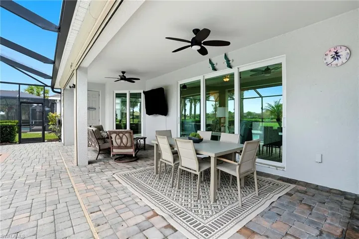 View of patio / terrace with outdoor dining area, a sunroom, glass enclosure, and a ceiling fan