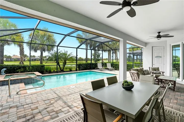 View of pool with a sunroom, a patio, glass enclosure, an outdoor hangout area, and a ceiling fan