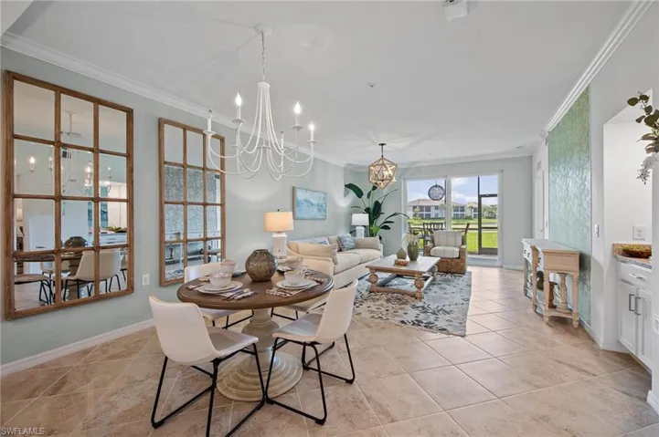 Dining room with a chandelier, ornamental molding, and light tile patterned floors