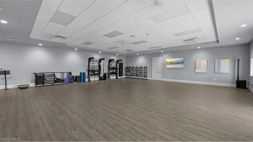 Workout area with wood finished floors and a paneled ceiling