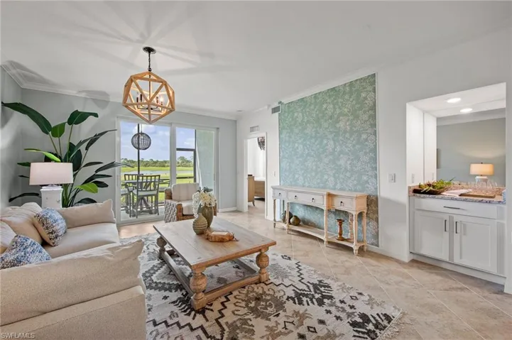 Living area with ornamental molding and a chandelier