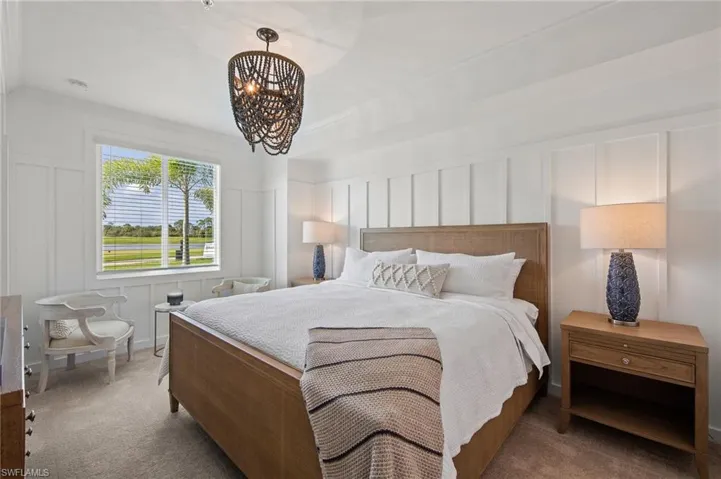 Bedroom with a decorative wall, a chandelier, carpet, and crown molding