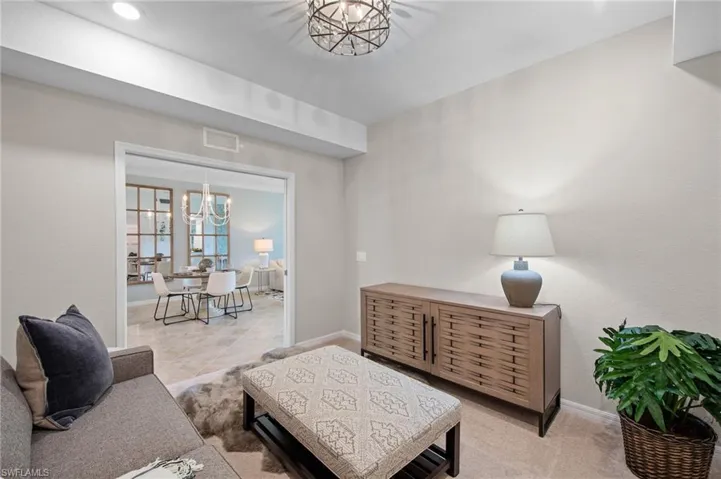 Living area featuring a chandelier and baseboards
