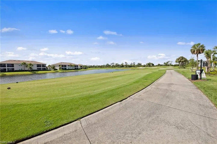 View of property's community with a water view, a lawn, and golf course view