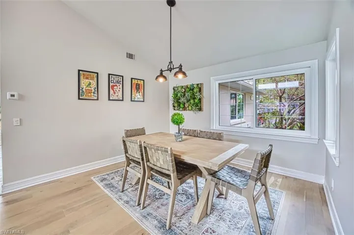 Dining area with vaulted ceiling and light wood finished floors