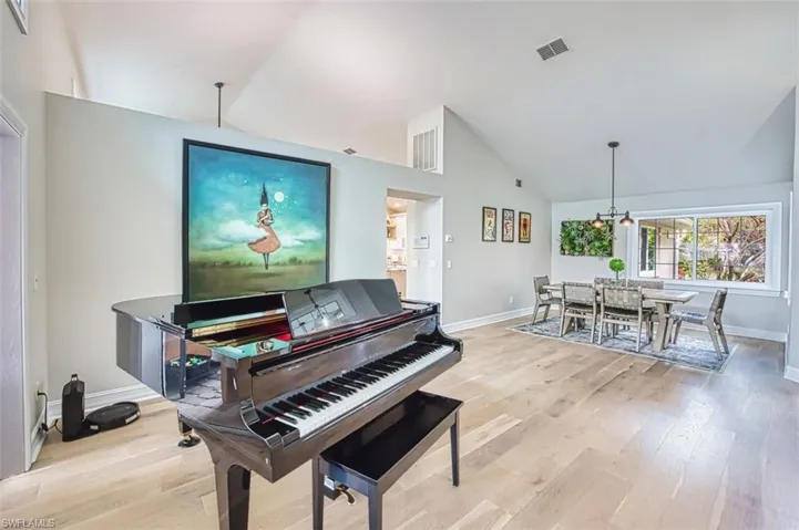 Sitting room featuring high vaulted ceiling and light wood finished floors