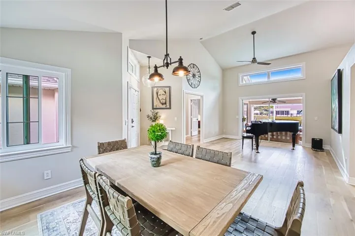 Dining room featuring a ceiling fan, light wood finished floors, and high vaulted ceiling