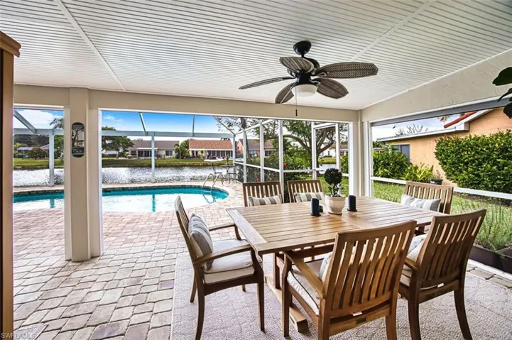 View of patio / terrace with outdoor dining area, a water view, an outdoor pool, a sunroom, and a lanai