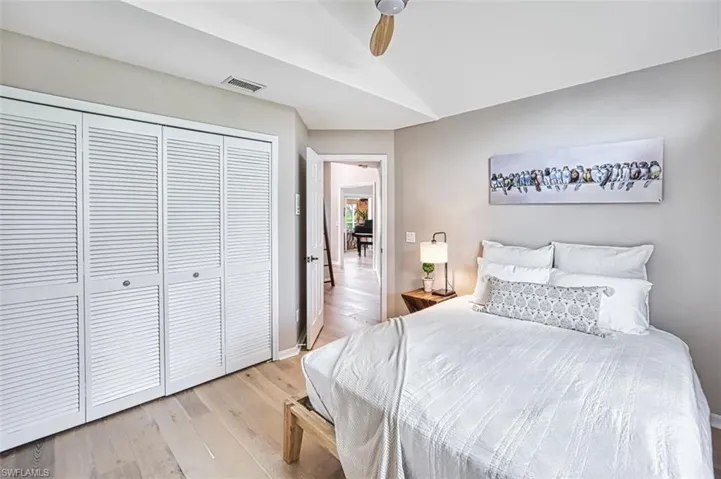 Bedroom featuring vaulted ceiling, light wood-style floors, a closet, and ceiling fan