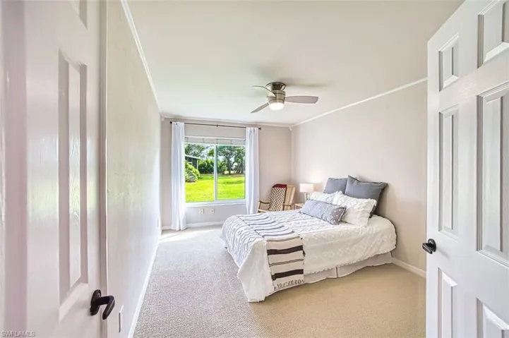Bedroom with crown molding, carpet floors, and a ceiling fan
