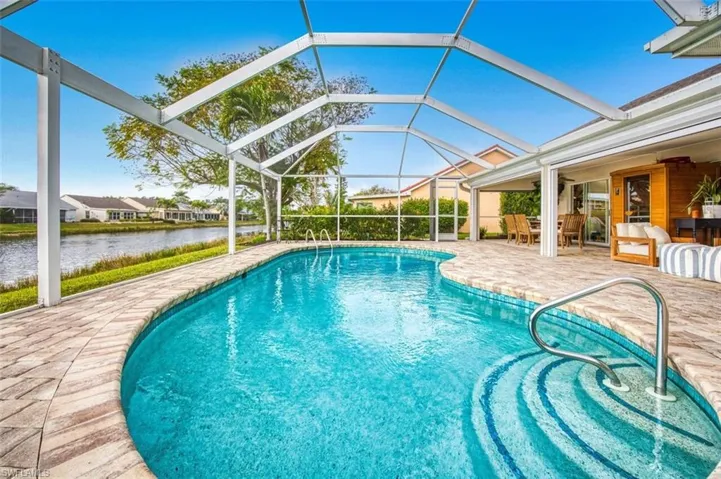 Outdoor pool featuring a sunroom, a patio, a lanai, a water view, and a residential view