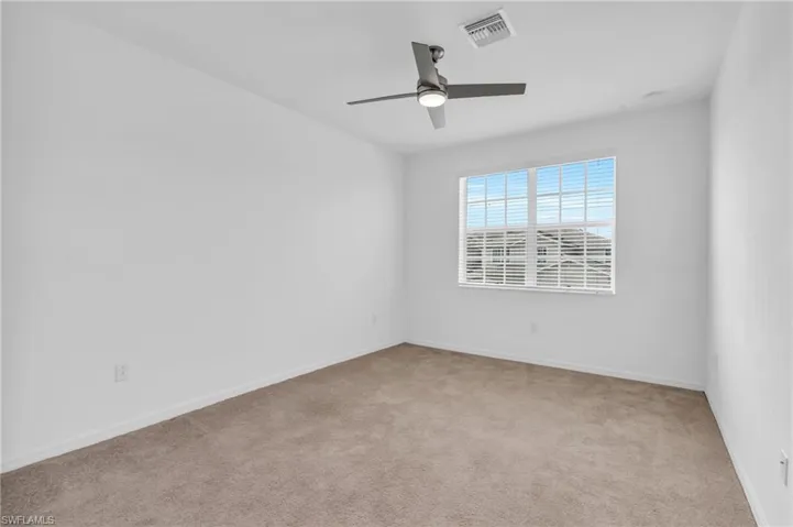 Carpeted empty room with ceiling fan