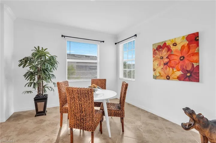 Dining area with light tile patterned floors and crown molding