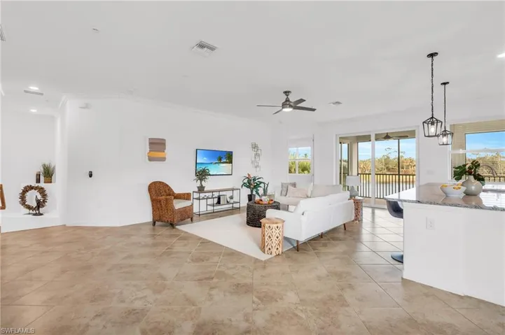 Living room with crown molding and ceiling fan with notable chandelier