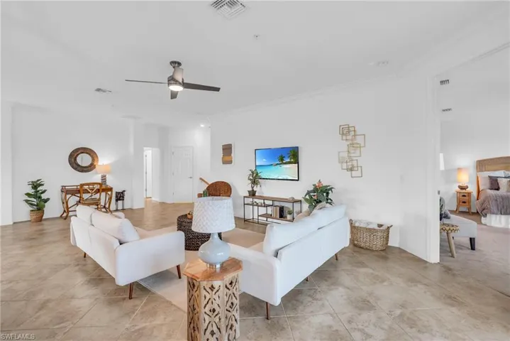 Living room featuring ceiling fan and crown molding
