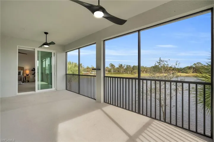 Sunroom featuring ceiling fan and a water view