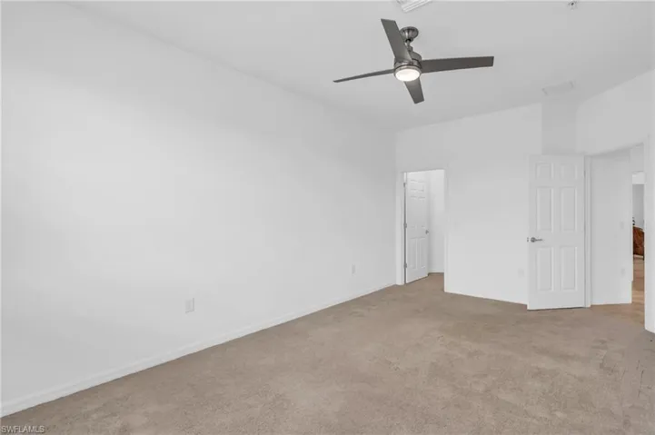 Carpeted empty room with ceiling fan