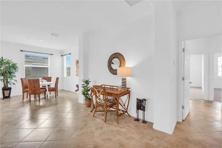 Hallway with light tile patterned floors and crown molding