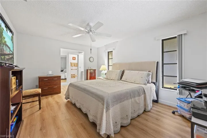 Wood-finish flooring with white walls and a ceiling fan
