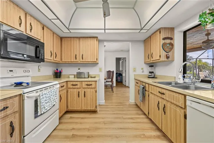Kitchen featuring wood-finish cabinetry, light-toned countertops, and wood-finish flooring