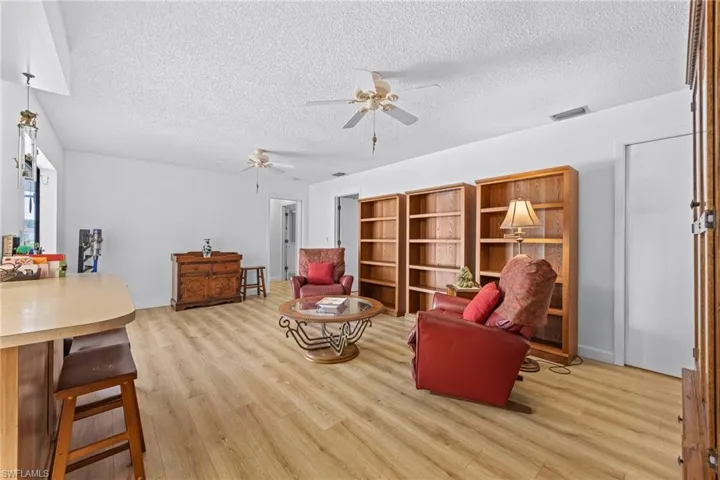 Wood-finish flooring throughout, white walls, and built-in shelving units