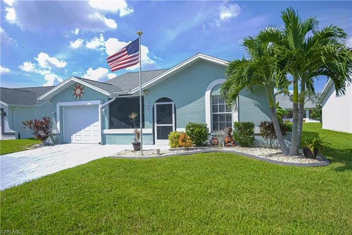 Well-maintained front lawn with established landscaping, mature palm trees, and a concrete driveway