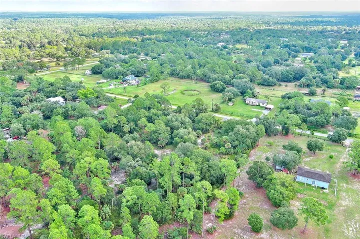 Aerial overview of property's location with a heavily wooded area