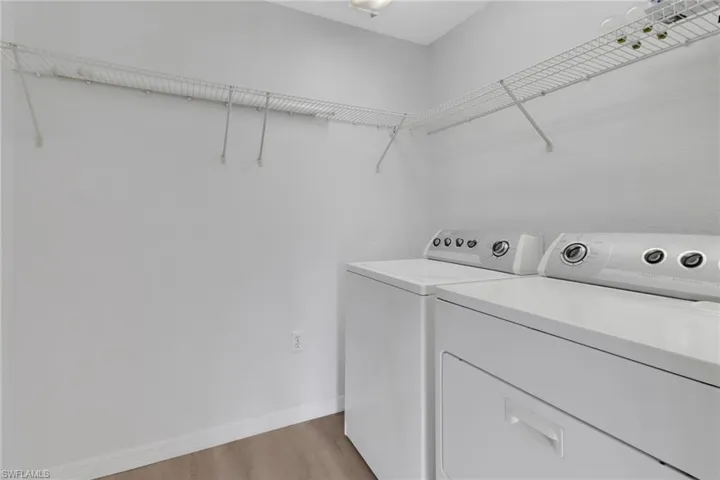 Laundry room featuring light hardwood / wood-style floors and washing machine and clothes dryer