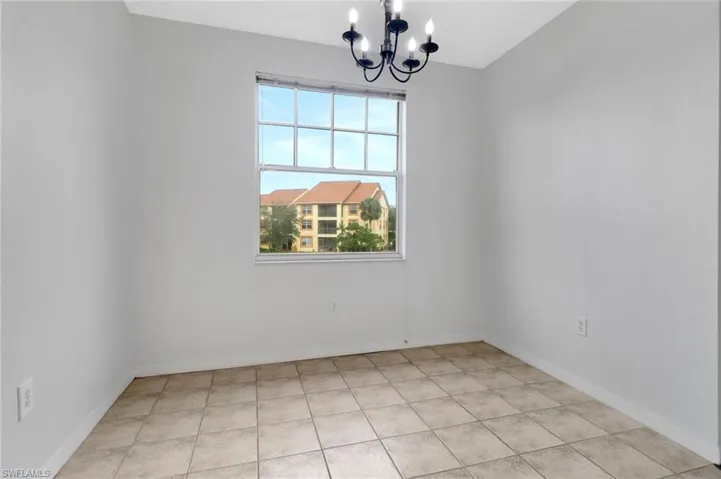 Spare room featuring a chandelier and light tile patterned floors