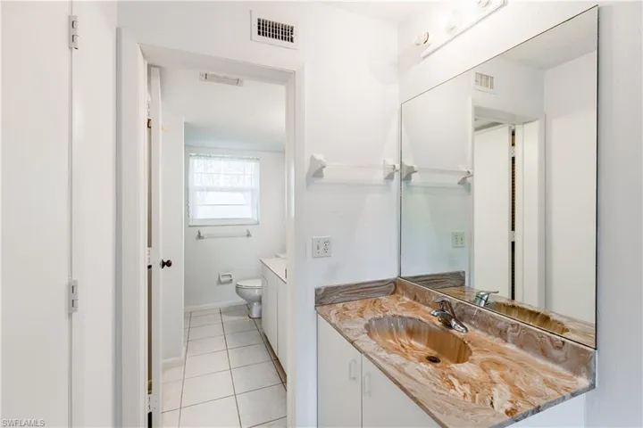 Bathroom featuring vanity, tile patterned floors, and toilet