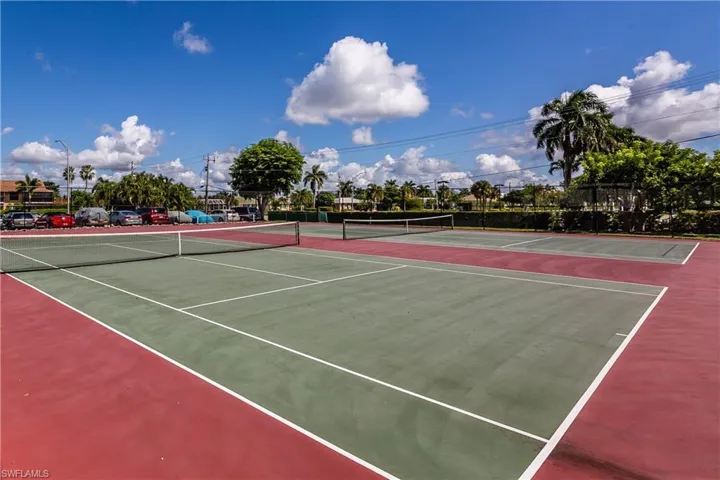 View of tennis court featuring basketball hoop