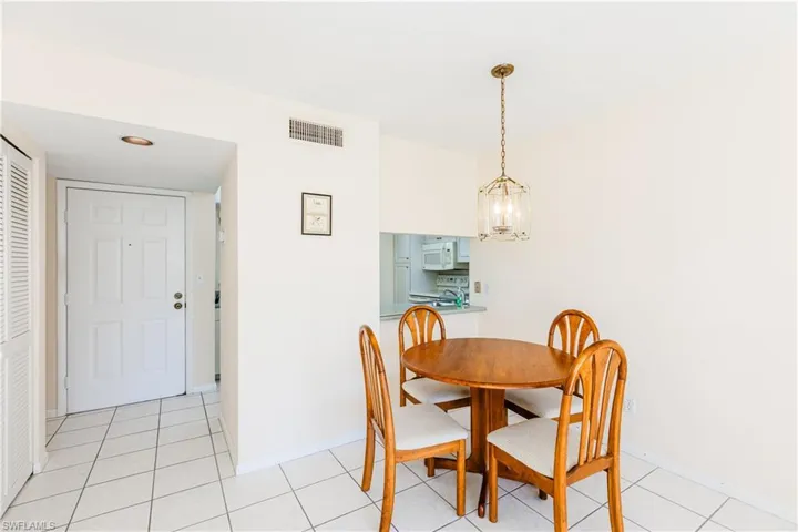 Dining room with light tile patterned floors and an inviting chandelier