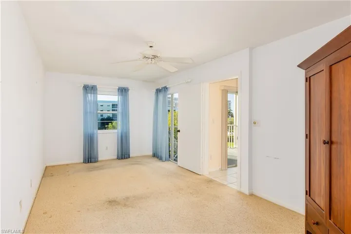 Carpeted empty room featuring ceiling fan