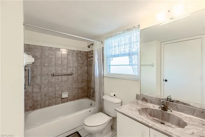 Full bathroom with shower / bath combo, vanity, and toilet