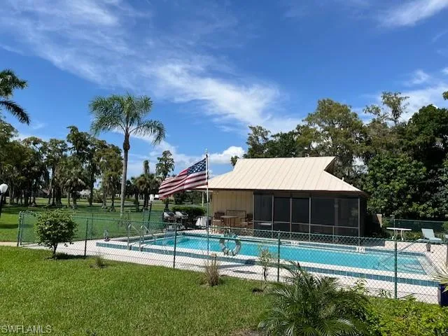 View of pool with a sunroom and a yard