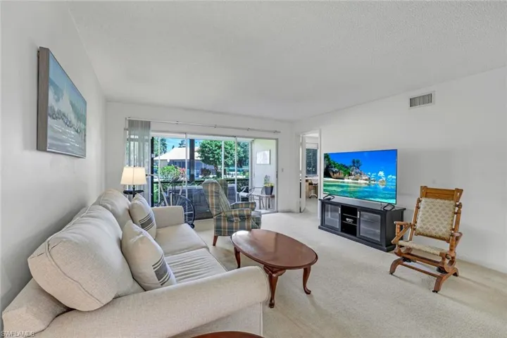 Living room with a textured ceiling and carpet floors