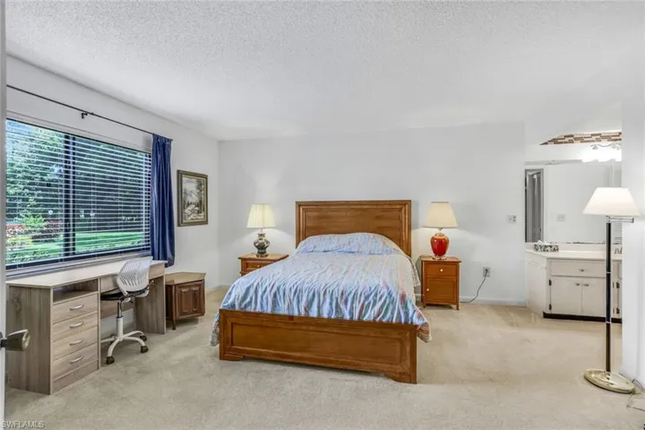 Bedroom with a textured ceiling and light colored carpet
