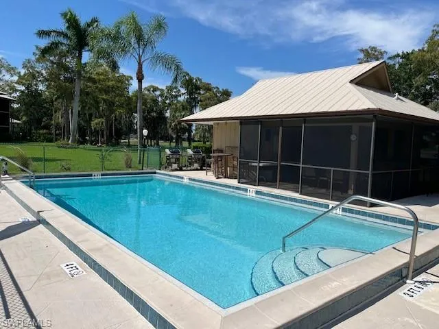 View of pool with a patio area, a lawn, and a sunroom