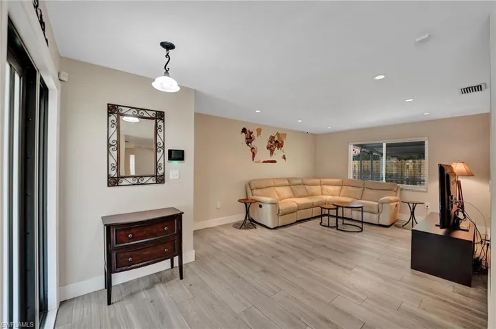 Living room featuring light wood-type flooring, baseboards, and recessed lighting