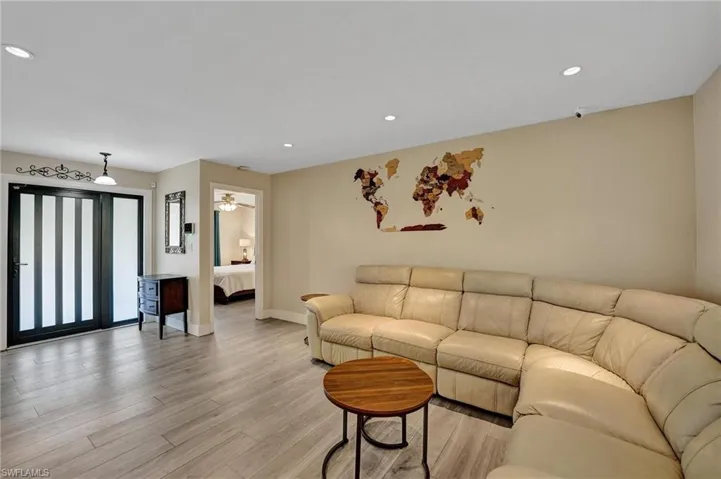 Living area with baseboards, light wood-style flooring, and recessed lighting