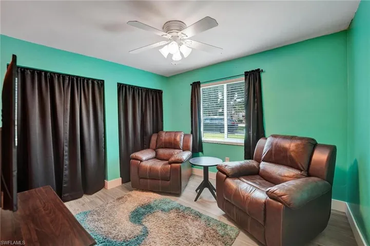 Sitting room featuring baseboards, a ceiling fan, and wood finished floors