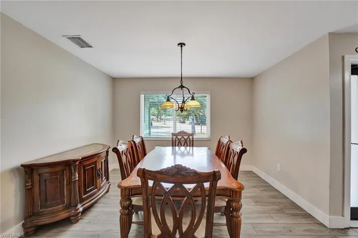 Dining area featuring a chandelier, baseboards, and light wood finished floors