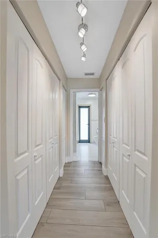 Hall with baseboards and light wood-type flooring