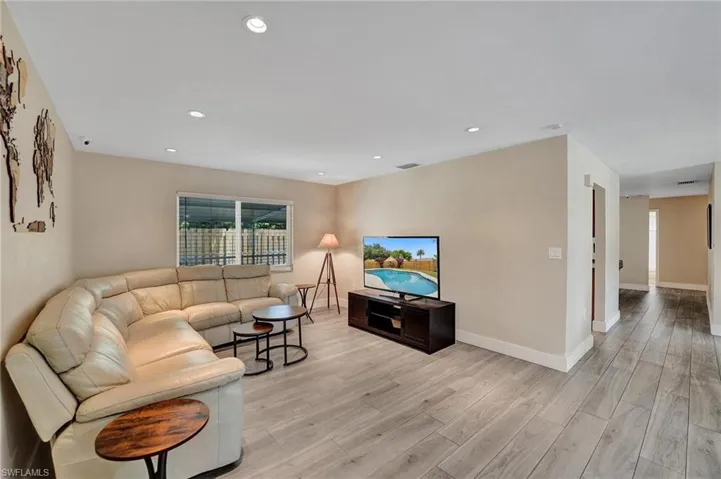 Living area with light wood-type flooring, baseboards, and recessed lighting
