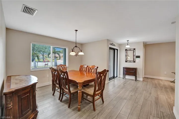 Dining area featuring light wood-style flooring, baseboards, and a chandelier