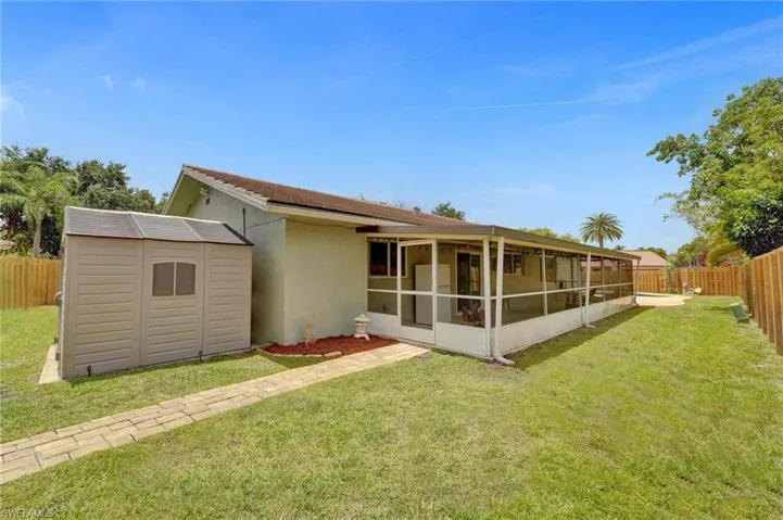Back of property with a sunroom and stucco siding