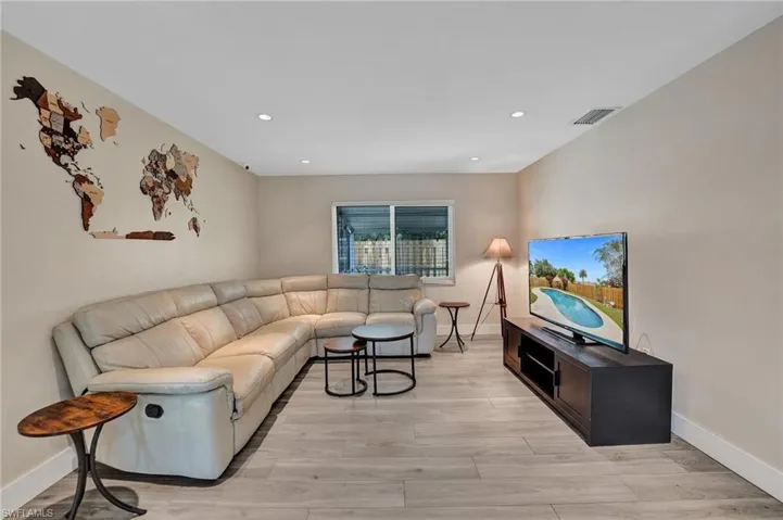 Living room with light wood-type flooring, recessed lighting, and baseboards